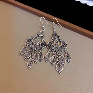 Close-up of silver ethnic tassel earrings with intricate floral and teardrop patterns