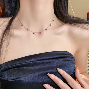 Détail d'un collier ras du cou en argent de style coréen avec des pendentifs en zircon rouge