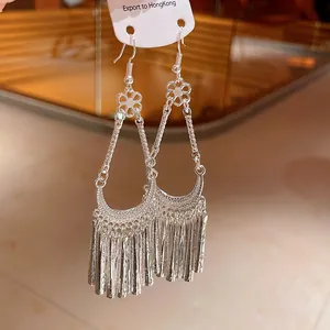 Detail showing the intricate silver flower and tassel design of ethnic drop earrings.