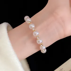 French vintage pearl bracelet with rhinestones worn on wrist, elegant gold jewelry
