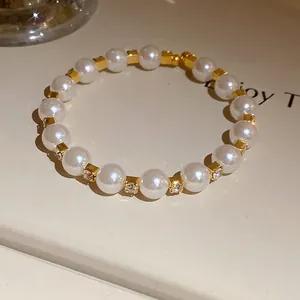 Macro view of elegant pearl beaded bracelet with sparkling rhinestones and gold spacers.