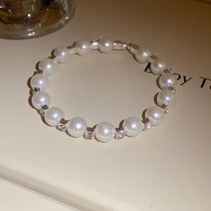 Detailed macro view of a vintage pearl bracelet featuring elegant sparkling rhinestone spacers