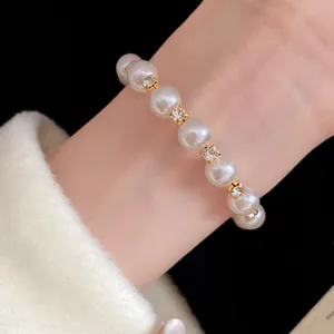Macro view of elegant pearl beaded bracelet with gold crystal spacers worn on wrist
