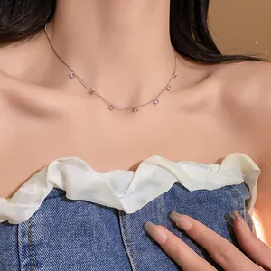 Vue détaillée d'un collier ras du cou en argent avec pendentifs en zircon rose sur cou