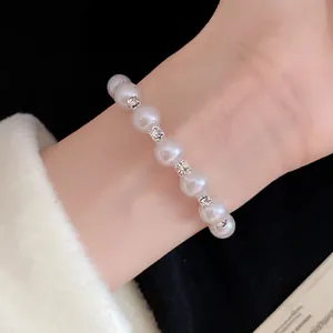 Detailed close-up of elegant faux pearl bracelet with rhinestones on a wrist
