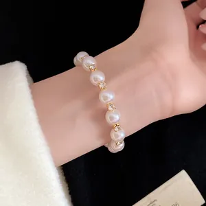 Close-up view of a French vintage style pearl and rhinestone beaded bracelet on a model