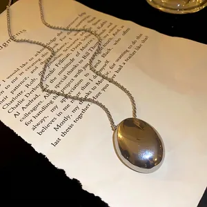 Modern minimalist silver titanium steel necklace featuring a smooth oval pendant design