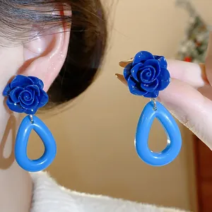 Gros plan détaillé de boucles d'oreilles rose bleue en acrylique avec pendentifs