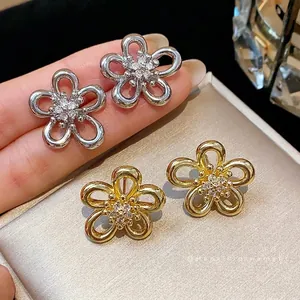 Minimalist zircon flower stud earrings with five-petal hollow design in gold and silver finish