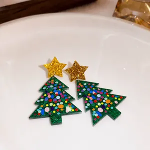 Detailed view of glittery Christmas tree earrings with gold stars and colorful ornaments