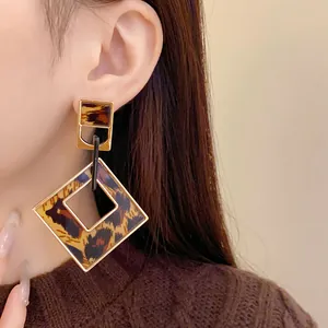 Detailed close-up of retro leopard print hollow rhombus earrings worn on a stylish model
