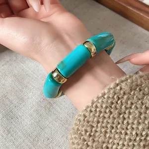 Detailed close-up view of bohemian marbled teal cylindrical elastic bracelet on wrist