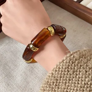 Detail view of retro Bohemian elastic bracelet with amber-style cylindrical beads