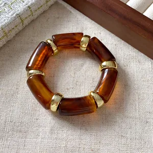 Detailed macro view of amber-toned cylindrical beads with gold spacers in retro style