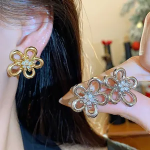 Detailed macro shot of elegant silver and gold zircon flower stud earrings on ear