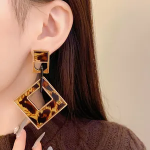 Vintage-style hollow rhombus earrings with leopard print shown on a model's ear.