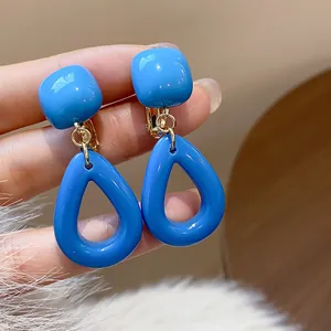 Gros plan détaillé de boucles d'oreilles géométriques en acrylique bleu vif et métal doré