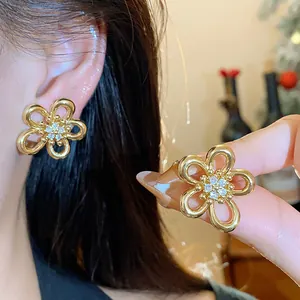 Detailed view of gold zircon flower stud earrings showing delicate petal design and stones.