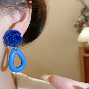 Vue détaillée de boucles d'oreilles vintage en acrylique bleu avec rose et goutte sur mannequin