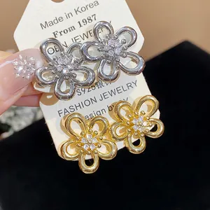Close-up of elegant zircon flower stud earrings with S925 silver needles on a display card