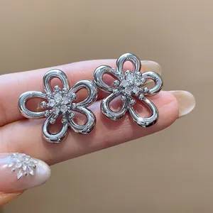 Close-up of silver-tone zircon flower stud earrings featuring elegant hollow petals