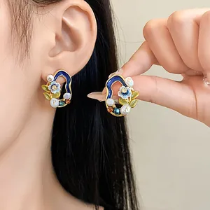 Detailansicht von eleganten Vintage-Ohrringen mit Süßwasserperlen und Blumen-Emaille