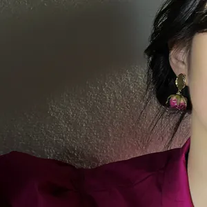Elegant vintage preserved pink rose bud earrings worn on ear with 925 silver needle post.