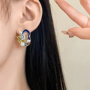 Detailansicht eines geometrischen Vintage-Ohrrings mit Süßwasserperlen am Model