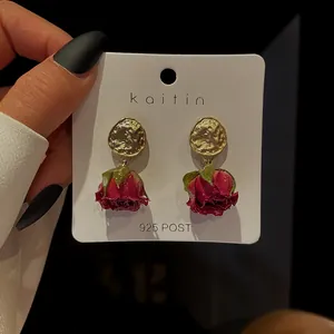 Detailed macro view of vintage preserved rose earrings with gold finish and S925 silver needles
