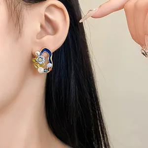 Nahaufnahme eines Vintage-Ohrrings mit geometrischen Blumen und Perlen am Modellohr