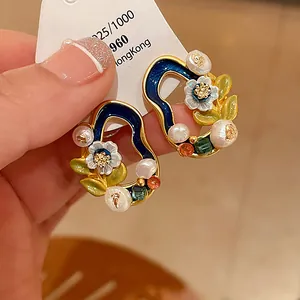 Makroansicht von Vintage-Ohrringen mit Emaille-Blumen und echten Süßwasserperlen