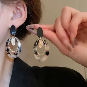 Primer plano de pendientes geométricos retro con estampado de leopardo carey