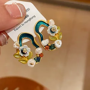 Nahaufnahme von Vintage-Ohrringen mit Emaille-Blumen und echten Süßwasserperlen