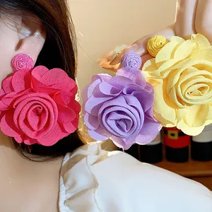 Close-up of vibrant chiffon rose flower earrings in pink, purple, and yellow tones.