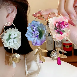 Elegant oversized fabric flower earrings with silver needle posts and colored glass droplets.