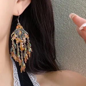 Orecchini pendenti etnici vintage con perline di vetro su una modella