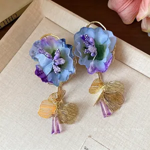 Elegant blue and purple fabric flower earrings with gold butterfly and glass drop details