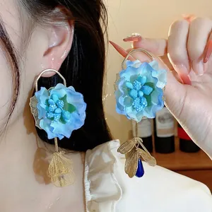 Exaggerated blue fabric flower earrings with silver needles and elegant gold details
