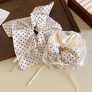 Dettaglio di un set di elastici a pois con pizzo delicato e fiocco in nastro bianco