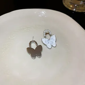 Elegante asymmetrische Schmetterlingsohrringe mit Perlen und Kristalldetails aus Silber