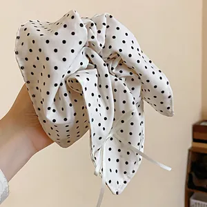 Primo piano di un elastico bianco in stile francese con pois neri e un grazioso fiocco