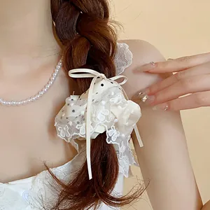 Dettaglio di un elegante elastico per capelli in pizzo bianco e pois stile francese