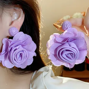 Close-up view of purple chiffon flower earrings showing delicate and soft petal textures