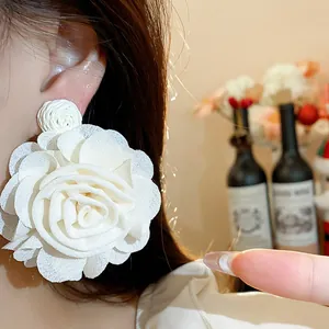 Detailed macro view of an elegant off-white chiffon flower earring with raffia textures