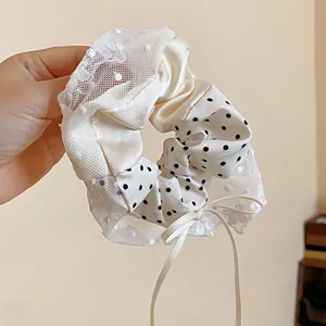 Primo piano di un elegante elastico in pizzo francese con pois e un delicato fiocco decorativo