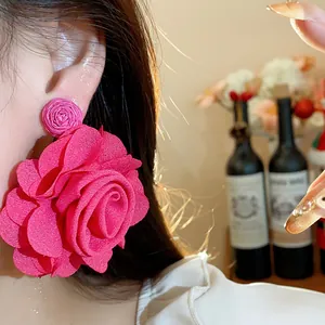 Close-up of premium fuchsia chiffon flower rose earrings shown on an Asian model's ear