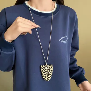 Nahaufnahme einer Dreieck-Halskette aus Kunstleder mit Leopardenmuster als Pulloverkette