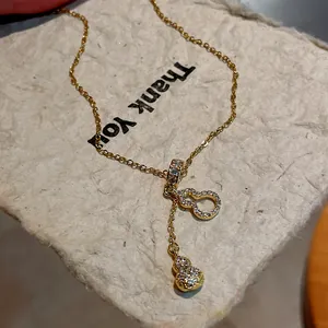 Close-up detail of gold-plated Wulu gourd pendant necklace with shimmering cubic zirconia