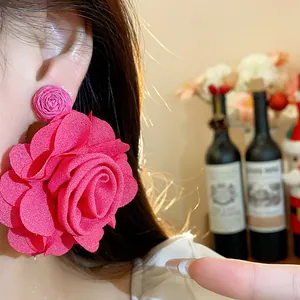Macro view showing the intricate chiffon petals and woven raffia of these pink earrings