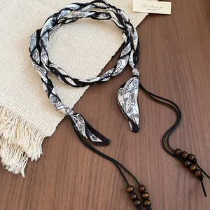 Detailed view of vintage paisley fabric waist chain with decorative wooden beads